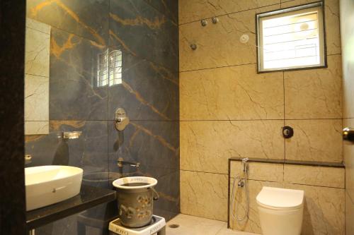 a bathroom with a toilet and a sink at ARS FARMSTAY in Munirābād
