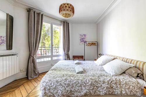 Un dormitorio con una cama grande y una ventana. en Apartment Paris 4° centre - Marais/Beaubourg, en París