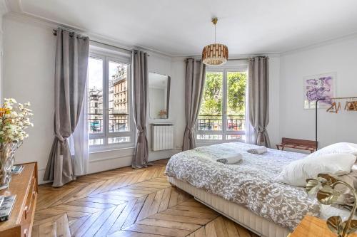 a white bedroom with a large bed and windows at Apartment Paris 4° centre - Marais/Beaubourg in Paris