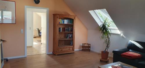 een woonkamer met een boekenplank en een raam bij Ferienwohnung in Etelsen in Langwedel