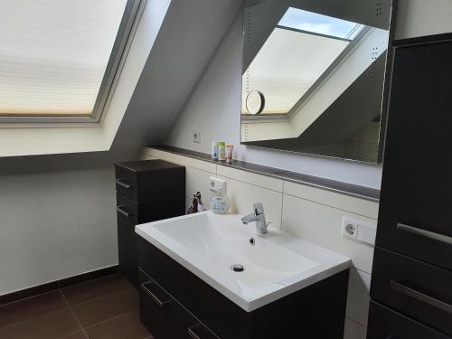 een badkamer met een wastafel en een spiegel bij Ferienwohnung in Etelsen in Langwedel