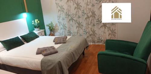 ein Schlafzimmer mit einem Bett und einem grünen Stuhl in der Unterkunft LM apartments Puentezuelas in Granada