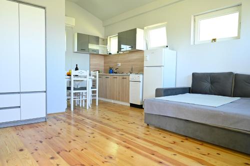 a bedroom with a bed and a kitchen with a table at Tina in Cetinje
