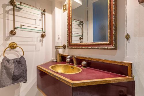 a bathroom with a gold sink and a mirror at Apartment Paris 4° centre - Marais/Beaubourg in Paris