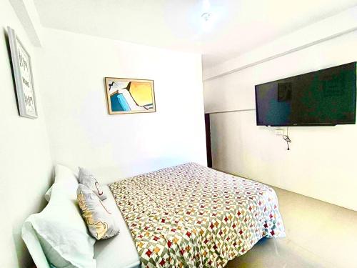 a bedroom with a bed and a flat screen tv at Treasure Beach in Carles
