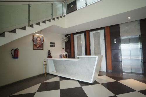 um átrio com um balcão e um piso xadrez em Nirmal Hotel And Resort em Bareilly