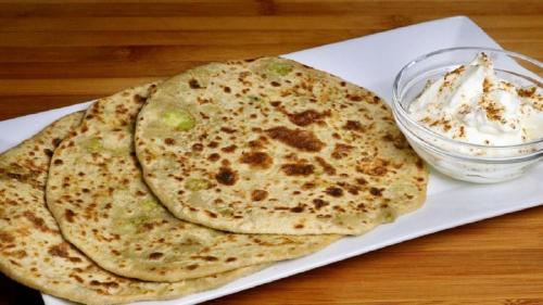 two tortillas on a plate with a bowl of whipped cream at HOTEL RV GOLDEN in Amritsar
