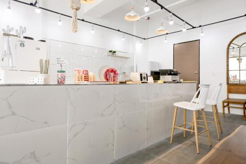 a kitchen with white marble countertops and white stools at W Hotel in Yangsan