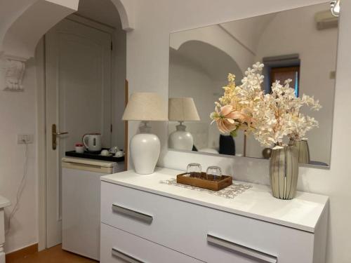 eine Küche mit einer weißen Theke mit Blumen in einer Vase in der Unterkunft Panoramic Villa in Amalfi in Amalfi