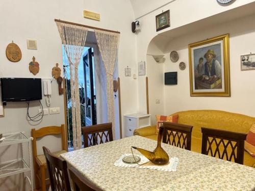 ein Esszimmer mit einem Tisch und einer Vase darauf in der Unterkunft Panoramic Villa in Amalfi in Amalfi