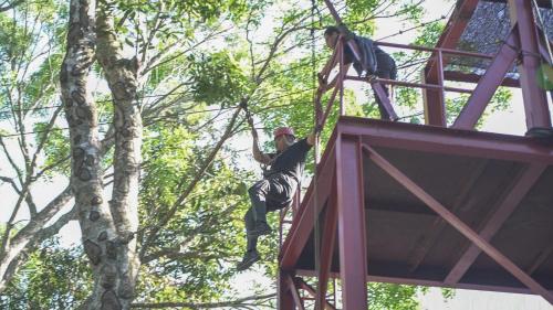 two men climbing up the side of a tree at Nilai Springs Resort Hotel in Nilai