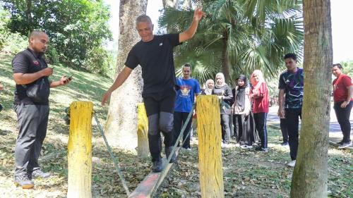 a man is jumping over a board in front of a group of people at Nilai Springs Resort Hotel in Nilai