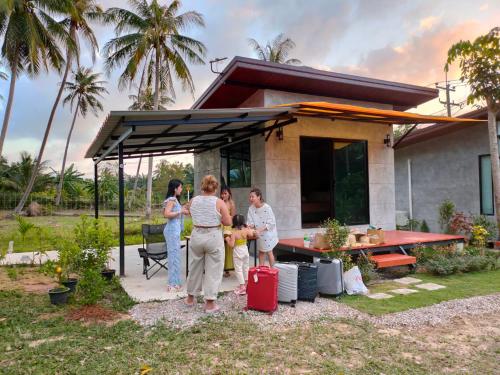 a group of people standing outside of a house at Eco Ventures Homestay (โฮมสเตย์ลุงบอส) in Chumphon