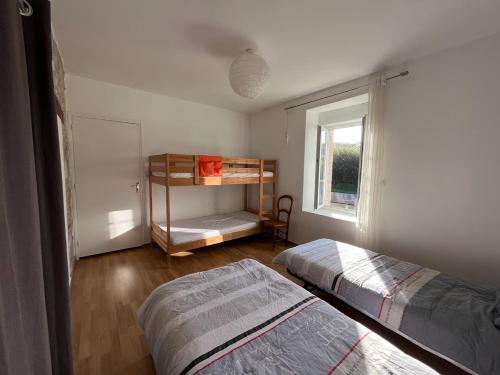 een slaapkamer met 2 bedden en een raam bij 14 maison 6 pers Les Gîtes Bigoudens in Plonéour-Lanvern