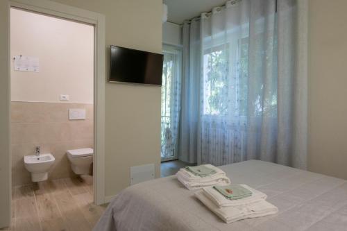 a bedroom with a bed and a toilet and a television at B&B Al Parco in Verona