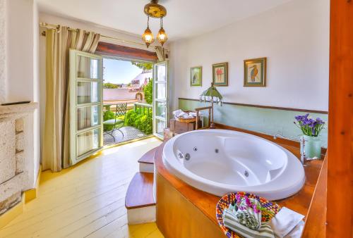 a large bathroom with a tub and a balcony at Palas Alaçatı - Adult Only in Alaçatı