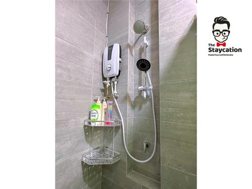 una doccia con telefono appeso a un muro di Staycation Homestay 19 Riverine Petanak Apartment a Kuching