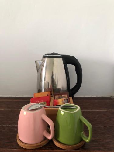 a tea pot and two mugs on a table at Maha di Nusa Lembongan in Nusa Lembongan