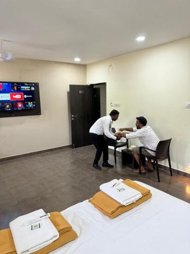 two men are helping a woman in a hair salon at Sangeetha Business Hotel in Chennai
