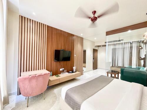 um quarto com uma cama, uma televisão e um sofá em HOTEL VEDANGAM INN ! VARANASI - Forɘigner's Choice ! fully Air-Conditioned hotel with Parking availability, near Kashi Vishwanath Temple, and Ganga ghat 2 em Varanasi
