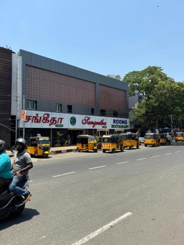 two people riding a motorcycle down a city street at Sangeetha Business Hotel in Chennai