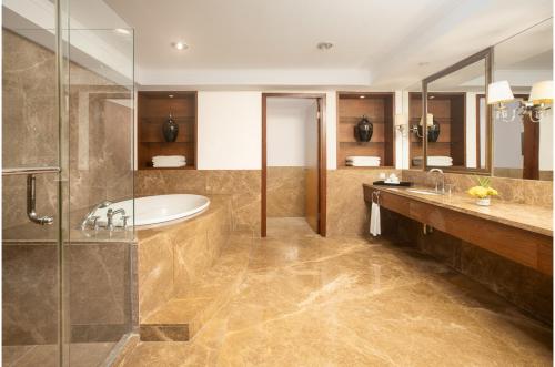 a bathroom with a tub and a sink at Aryaduta Medan in Medan