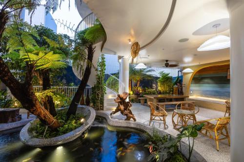 a living room with a koi pond and palm trees at Saha Casa Boutique Hotel Da Nang in Da Nang
