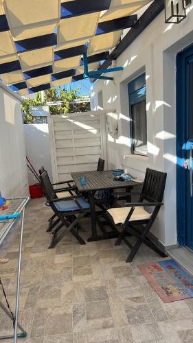 un patio con mesa y sillas bajo toldo en Aegean Paradise, en Psérimos