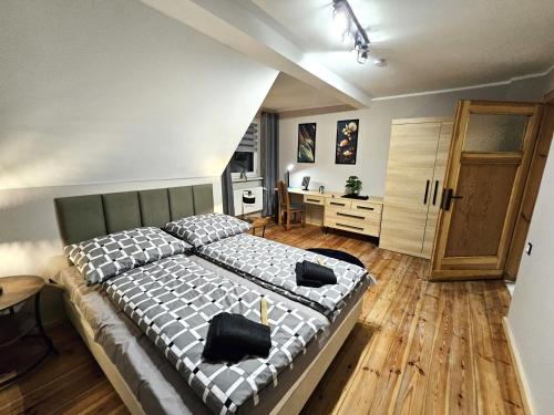 a bedroom with a large bed and a desk at Family Rooms in Zabrze