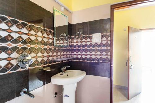 a bathroom with a sink and a mirror at Indu BNB Shimla in Shimla