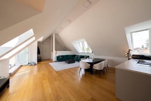 eine Küche und ein Wohnzimmer mit einem Tisch und Stühlen in der Unterkunft Luxury Penthouse Schönbrunn in Wien