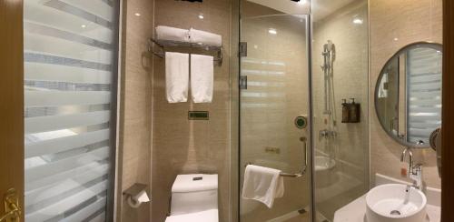 La salle de bains est pourvue d'une douche, de toilettes et d'un lavabo. dans l'établissement 汝州维也纳酒店, à Yüchow