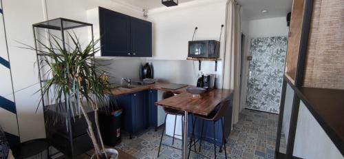 een kleine keuken met een bureau en een televisie bij Appart n°22, VUE MER, Plage in Perros-Guirec