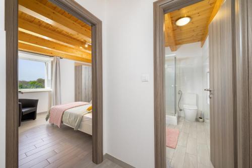 a bedroom with a bed and a bathroom at Villa Azinetti in Štokovci