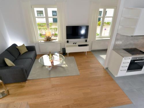a living room with a couch and a tv at Dat Dörphus am Bodden - WG 02 in Groß Zicker