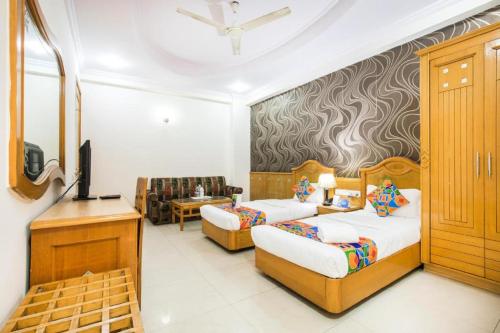 Cette chambre comprend deux lits et une télévision. dans l'établissement Hotel Kochar Continental, à New Delhi
