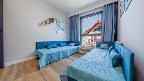 sala de estar con 2 camas y ventana en Apartamenty Sun & Snow Kaszubska Bryza ll, en Hel