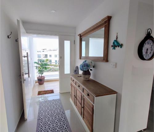 a hallway with a dresser with a mirror and a clock at Holiday apartment with astonishing views in Ayios Yeoryios