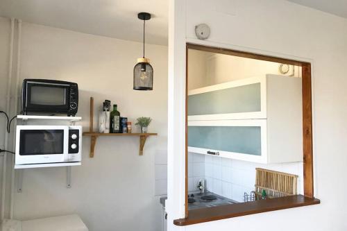 un miroir dans une cuisine avec un micro-ondes et une télévision dans l'établissement Studio de 20m2 Auxerre, à Auxerre