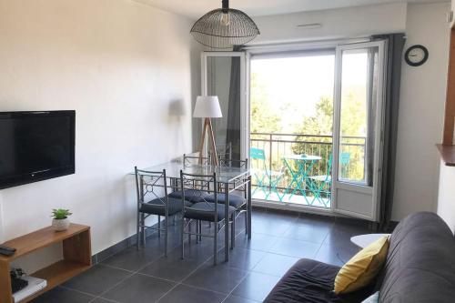 un salon avec une table et des chaises et un balcon dans l'établissement Studio de 20m2 Auxerre, à Auxerre