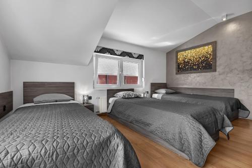 a bedroom with two beds and a painting on the wall at Dormir Apartments in Zagreb