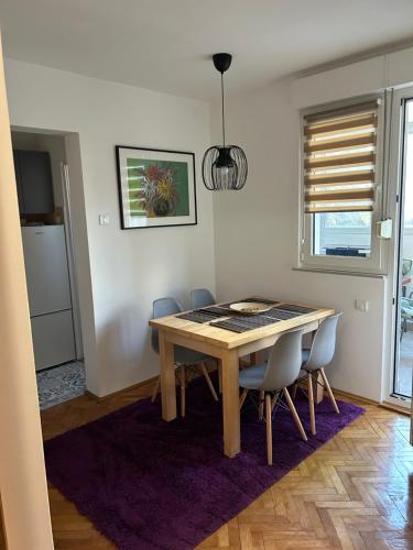ein Esszimmer mit einem Holztisch und Stühlen in der Unterkunft Martina Lux in Belgrad