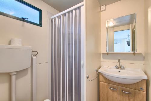 W łazience znajduje się umywalka i lustro. w obiekcie Camping Residence Oliva w Rabacu