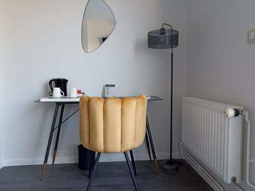 a room with a table with a chair and a desk with a lamp at Hotel de Champagne in Épernay