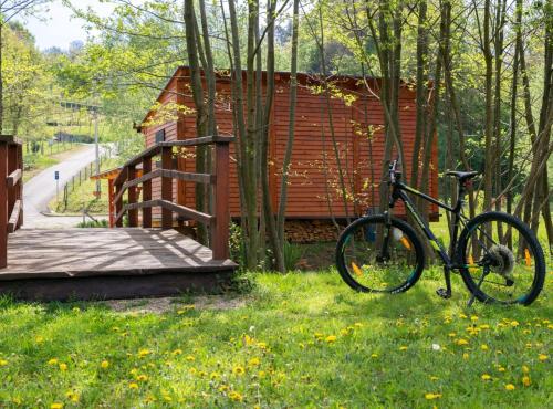 a bike parked in the grass in front of a cabin at Robinzonski Kamp Hofman in Varaždin
