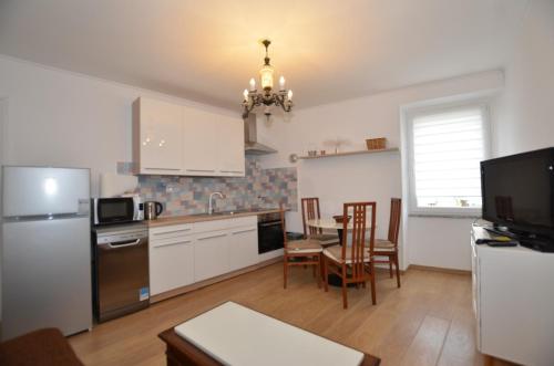 een keuken met een koelkast en een tafel met stoelen bij Moris Apartman in Rovinj