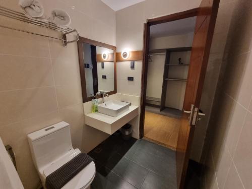 a bathroom with a toilet and a sink and a mirror at Altori Park Hotel in General Santos