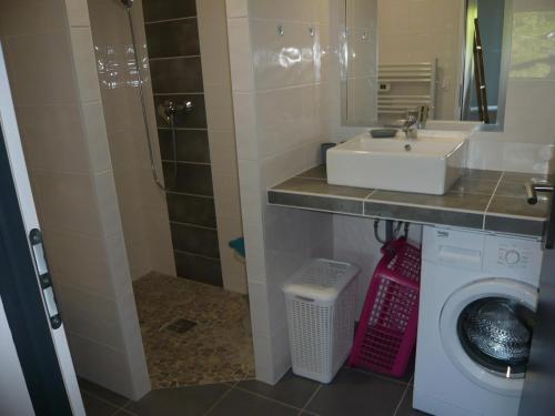 une salle de bain avec un lavabo et une machine à laver dans l'établissement Meublé de tourisme à l'entrée de Royan, à Médis