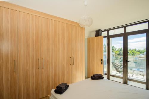 a bedroom with a bed and a large window at Palm Biche Residence in Trou aux Biches