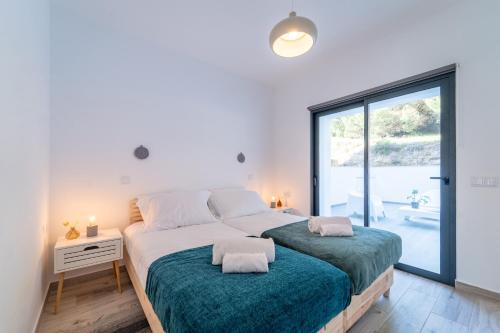 a bedroom with two beds and a large window at Apartment Nascer do Sol in Aljezur